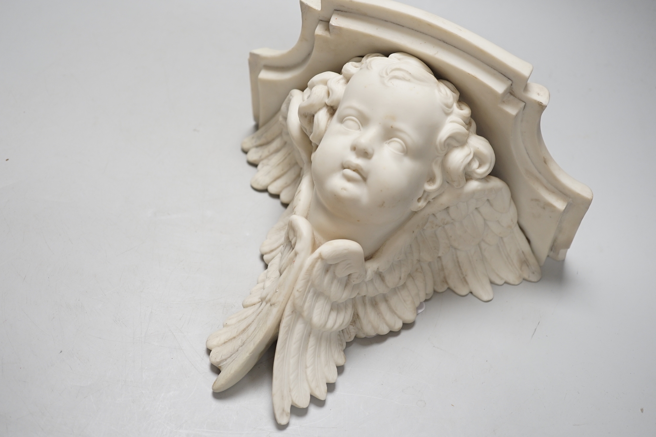 A pair of framed 17th / 18th century gilt-bronze putti mounts, each 7cm, and a 19th century parian 'cherub' bracket, 20cm high